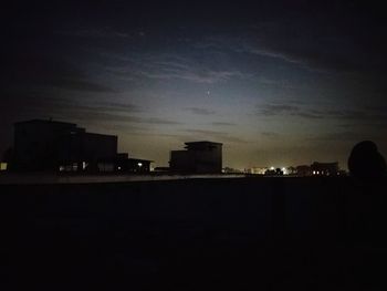 Silhouette buildings against sky at night