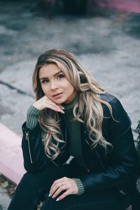 Portrait of beautiful young woman sitting outdoors