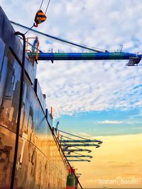 Low angle view of cranes against sky