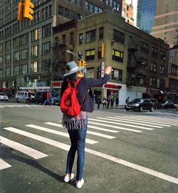 Full length of woman standing on road in city