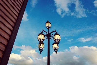 Low angle view of illuminated street light against sky