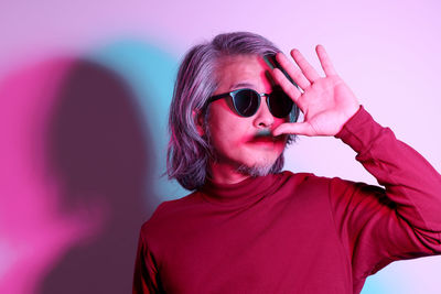 Portrait of young woman wearing sunglasses against sky