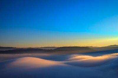 Scenic view of landscape against blue sky during sunset