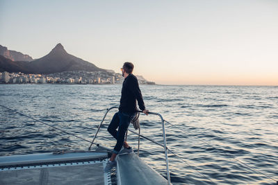 Full length of man standing on sea against clear sky