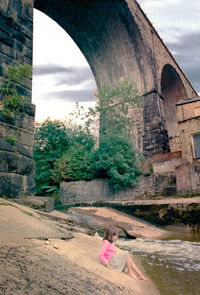 Woman by historic building against sky