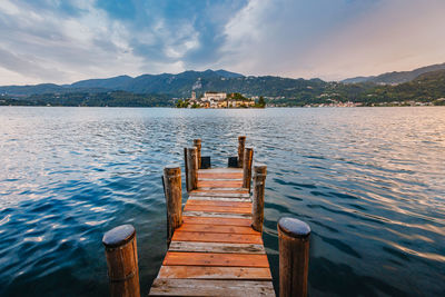 Wooden pier over lake against sky