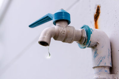 Low angle view of water drop dripping from faucet