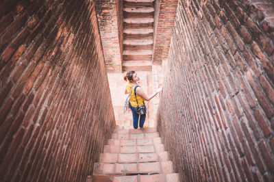 High angle view of woman standing on steps of historical building