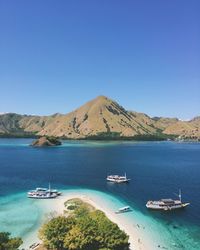 Sailboats in sea against clear blue sky