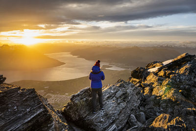 Figure at sunset above queenstown and lake, remarkables new zeala