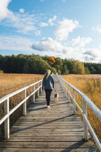 Rear view of woman walking on boardwalk