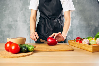 Midsection of man holding vegetables and cutting board