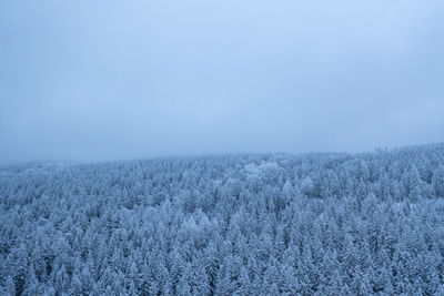 Scenic view of snow covered land against sky