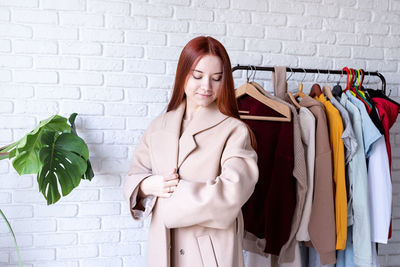 Young woman standing against wall