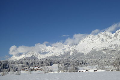 Scenic view of snowcapped mountains against blue sky