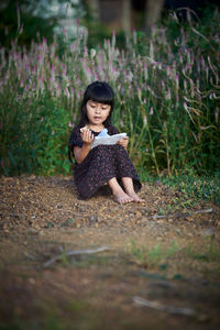 Portrait of a smiling woman sitting on land