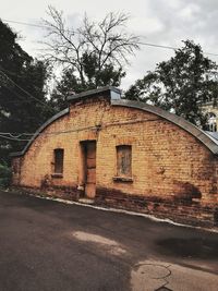 Old building by road against sky