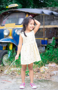 Smiling girl looking away while standing outdoors