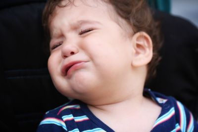 Close-up of cute baby boy crying while sitting on chair