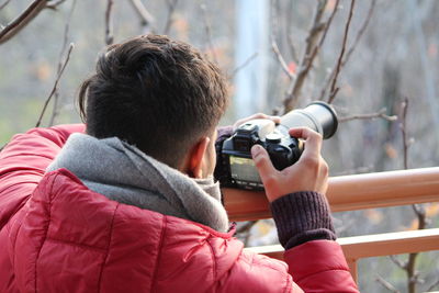 Side view of man photographing with camera