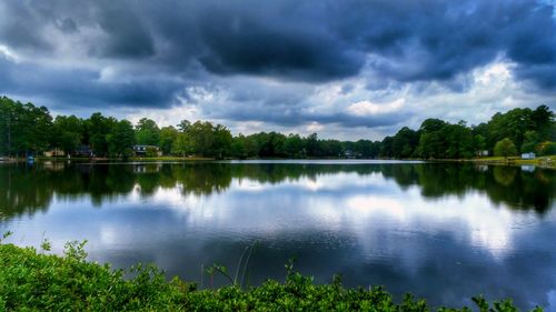 Scenic view of calm lake against cloudy sky