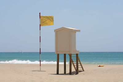 Lifeguard hut on beach against clear sky