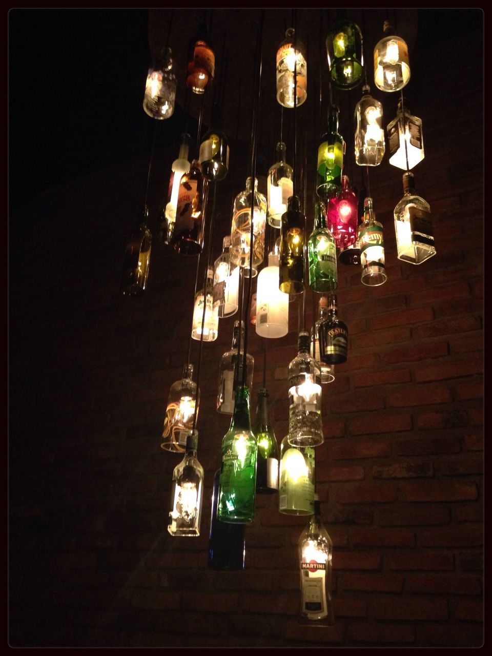 illuminated, indoors, lighting equipment, decoration, hanging, night, lantern, electricity, candle, in a row, arrangement, electric lamp, variation, wall - building feature, electric light, large group of objects, lamp, no people, glowing, still life