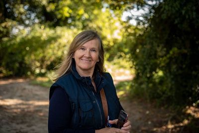 Portrait of smiling woman against trees