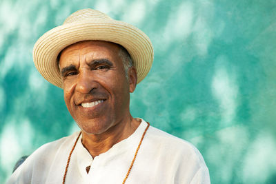 Portrait of man wearing hat against wall