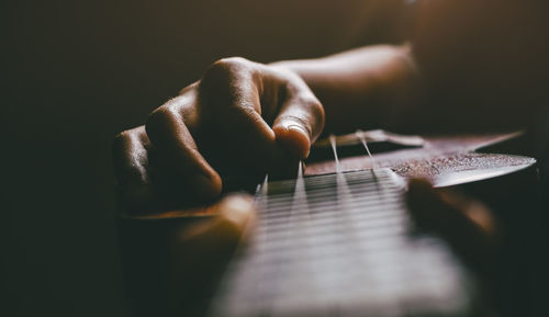 Midsection of person playing guitar