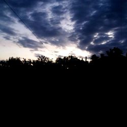 Silhouette trees against sky during sunset