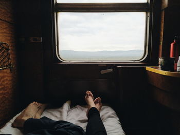 Low section of man lying on train window