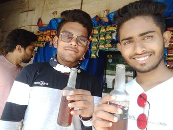 Portrait of smiling young man holding drink