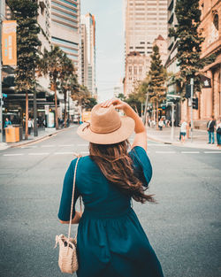 Rear view of woman standing on city street