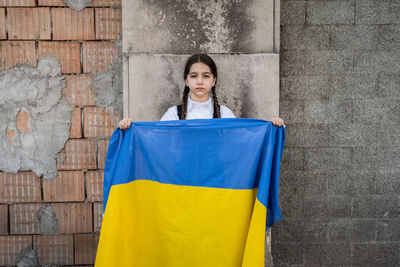 Portrait of woman standing against wall