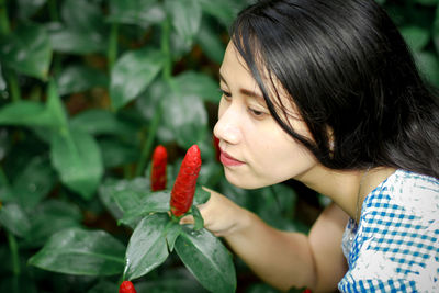 Close-up of woman holding plant outdoors