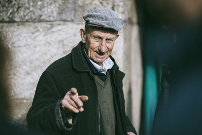 Portrait of man wearing hat standing against blurred background