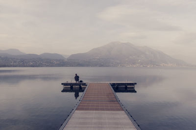 Man on lake against sky