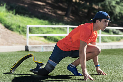 Side view of young athlete with prosthetic leg on running track