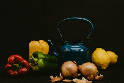 Close-up of fruits and vegetables on table against black background