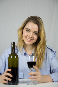 Portrait of smiling young woman holding drink