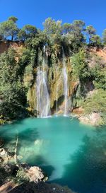 Scenic view of waterfall against sky