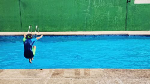 Rear view of person jumping in pool