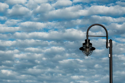 High section of lamp post against clouds