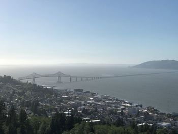 High angle view of cityscape by sea against clear sky