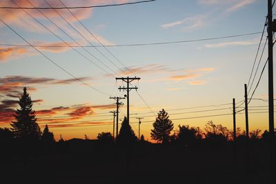 Silhouette of electricity pylon at sunset