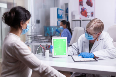 Female doctor examining patient at home