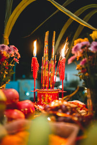 Illuminated candles in temple against building