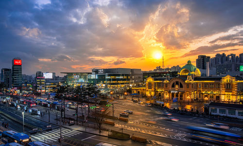 Illuminated cityscape against sky during sunset