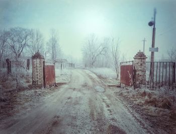 Railroad tracks by road during winter